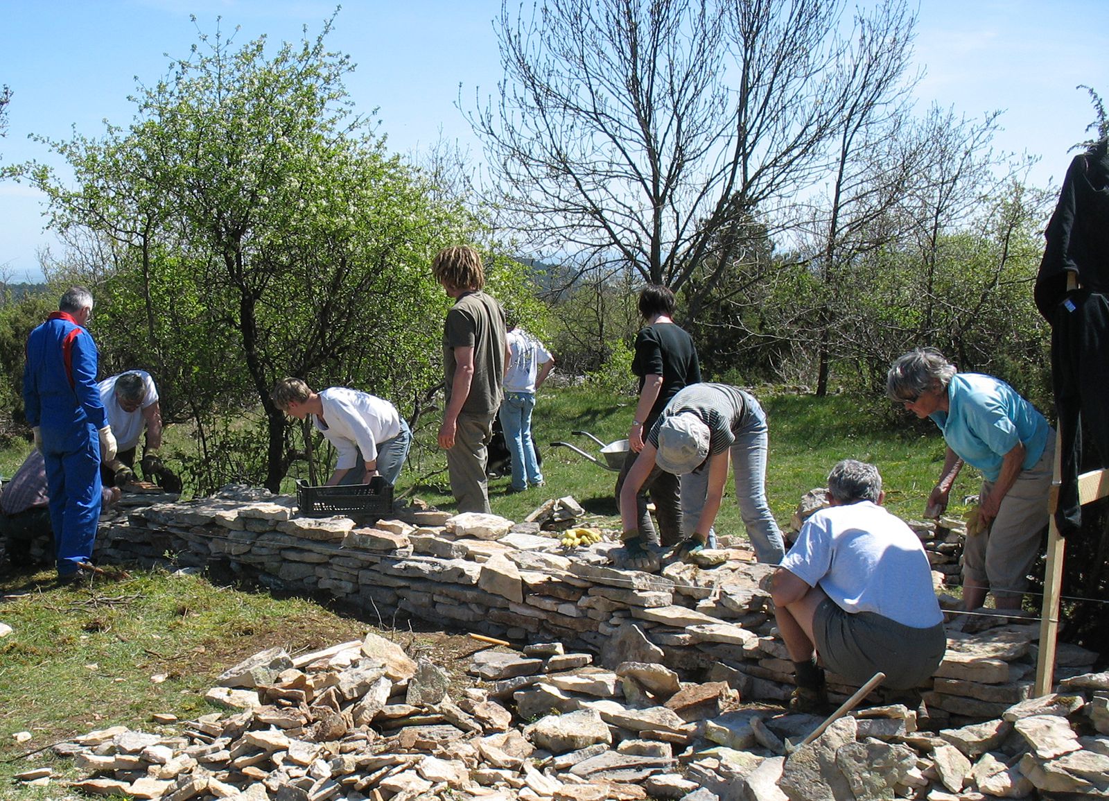 Adhérents participant à un chantier participatif de restauration de muret en pierres sèches